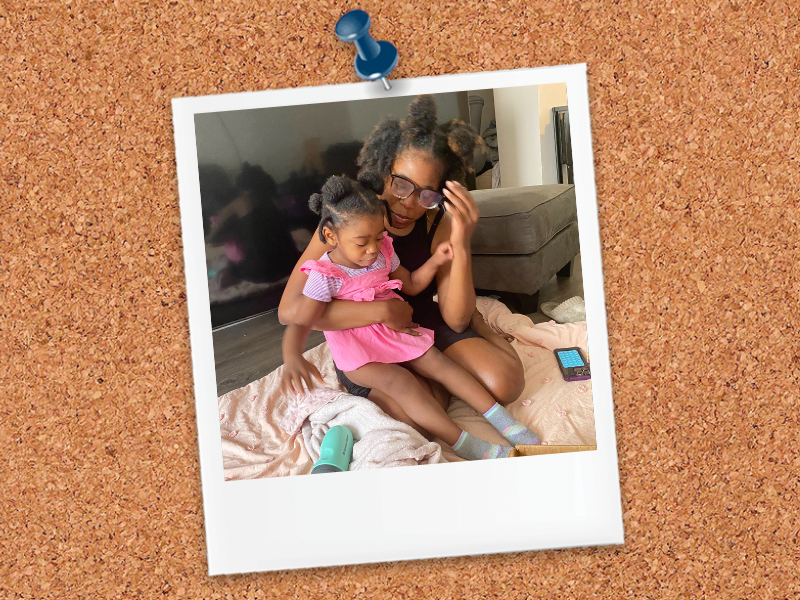 Little girl sitting on her mother's lap while they work on physical therapy exercises at home.