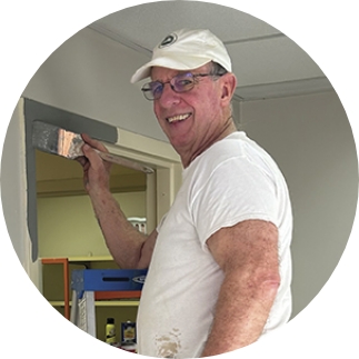 MAIN_VOLUNTEER_ongoingR Man painting a door frame - Ongoing Volunteering