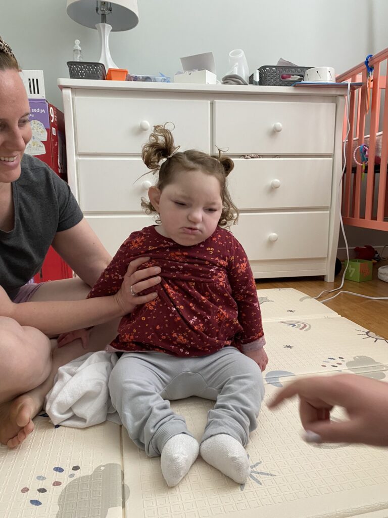 Anna's Early Intervention therapists work with Anna at home in her bedroom, help her learn to sit up.