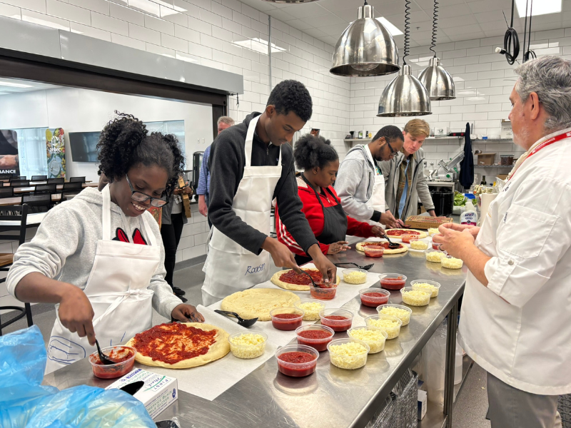 Participants from SOAR365's Pre-ETS and Supported Employment programs learn to cook pizzas and make salads in Performance Foodservice's commercial kitchen