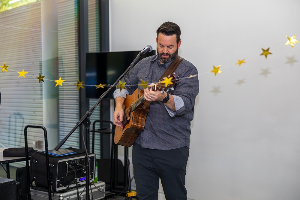 Volunteer musician Clay Mottley plays the acoustic guitar at SOAR365's Adult Day Support prom.
